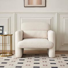 a white chair sitting in front of a painting on the wall