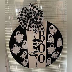 a door hanger decorated with black and white halloween decorations, hanging on a window