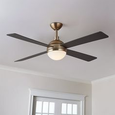 a ceiling fan that is mounted to the ceiling in a room with white walls and windows