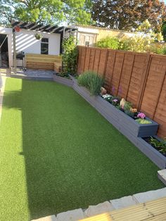 a backyard with artificial grass and wooden fence