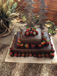 a triple layer chocolate cake with strawberries on top