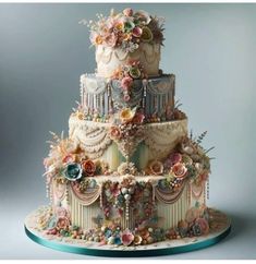 a three tiered cake decorated with flowers and pearls