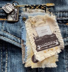 an old fashioned typewriter on the back pocket of someone's jean pants with a keychain attached to it