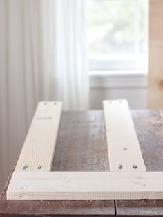 a close up of a wooden table with white paint and nails on the wood planks