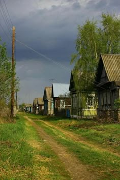 an old dirt road leading to several small houses