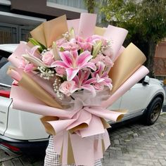 a bouquet of pink flowers in front of a car