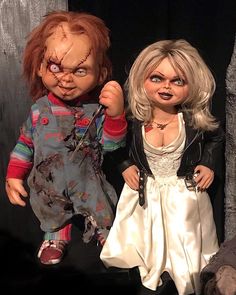 two creepy dolls standing next to each other