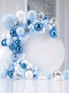 blue and white balloons are arranged in the shape of a circle on top of a table