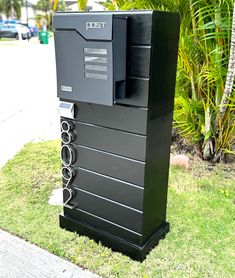 an electronic device sitting on top of a green grass covered field next to a sidewalk