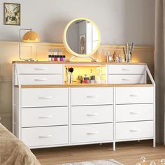 a white dresser with a mirror and lights on it