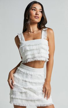 Get ready to turn heads in the Lylah Two Piece Set - Fringe Crop Top And Mini Skirt Set in Ivory! This trendy co-ord skirt and crop top combo is perfect for a night out with the girls or any party occasion. The white fringe detailing adds a fun and playful touch, while the square neckline gives it an edgy vibe. Made from comfortable cotton fabric, this sleeveless set will keep you cool all night long. Pair it with your favorite heels and get ready to be the center of attention wherever you go! P Two Piece Skirt Set Classy, White Fringe Skirt, Fringe Crop Top, Pink Polka Dot Dress, Mini Skirt Set, White Fringe, Strapless Crop Top, Ruffle Mini Skirt, Puff Sleeve Crop Top