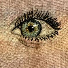 an eye is drawn on the side of a piece of fabric