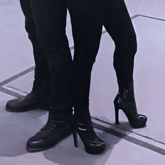 two people standing next to each other wearing high heeled shoes and black pants,