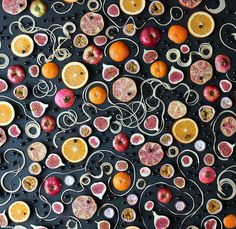 an art work made out of fruit and metal wire on a black surface with white writing