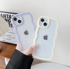 someone holding up two iphone cases in their hands