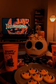 halloween treats are arranged on a table in front of a television and cup of coffee