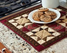 cookies and milk on a kitchen counter with a quilted placemat in the foreground