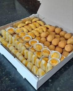 a box filled with lots of different types of donuts on top of a table