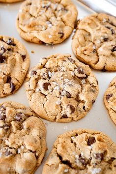 chocolate chip cookies are lined up on a baking sheet