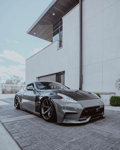 a silver sports car parked in front of a building