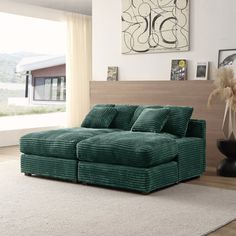 a green couch sitting on top of a white rug