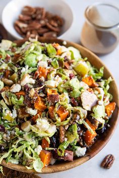 a salad in a bowl with nuts on the side