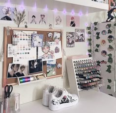 a white desk topped with lots of clutter and pictures next to a wall covered in magnets