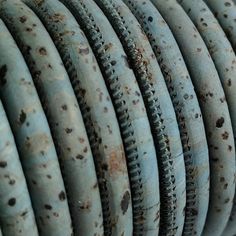 many circular objects are arranged together in a row on the wall, some rusted