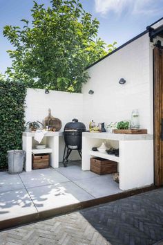 an outdoor bbq area with potted plants and grilling equipment on the patio