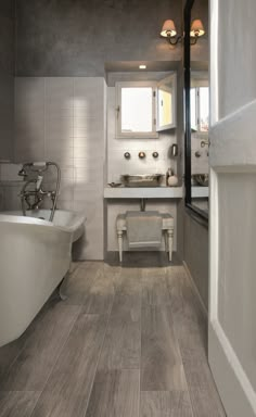 a bathroom with a tub, sink and bathtub in the middle of the room