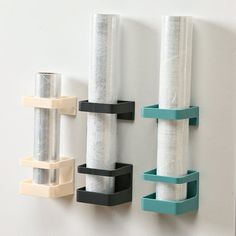 three rolls of toilet paper are hanging on the wall