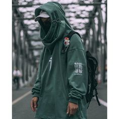 a man wearing a green hoodie is walking down the street