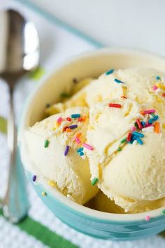 two scoops of ice cream with sprinkles in a bowl on a table