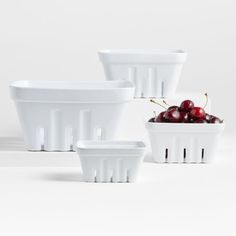 three white bowls with cherries in them