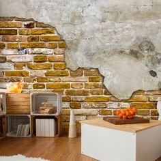 an old brick wall in a living room with white furniture and oranges on the table