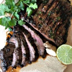 steak with cilantro, lime and parsley on a cutting board