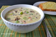 a white bowl filled with soup next to a slice of bread on top of a table