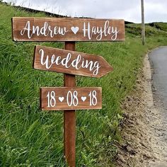 a wooden sign that says and arrow hayley wedding with hearts on it next to a road