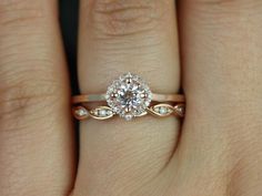 a woman's hand with a diamond ring on top of her finger and an engagement band