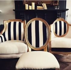 two black and white striped chairs sitting next to each other in front of a mirror