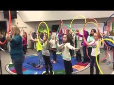 children are playing with hoop tossers in an indoor gym