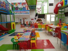 the children's playroom is brightly colored and has lots of tables and chairs