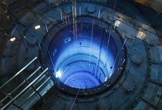 the inside of a large metal structure with blue light coming from it's center