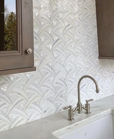 a white sink sitting under a bathroom mirror next to a wooden cabinet and counter top