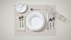 the place setting is ready to be served with silverware and utensils,