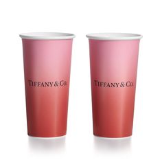 two pink cups with the words tiffany & co on them are sitting side by side