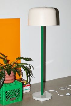 a green lamp sitting next to a potted plant