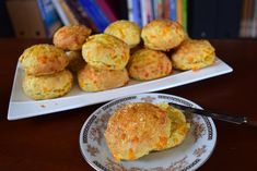 a plate with some biscuits on it next to a pile of muffins