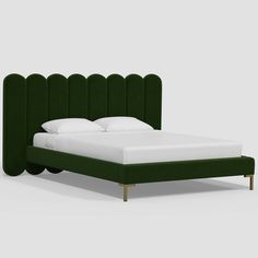 a bed with green headboard and white sheets on top of it, in front of a gray background