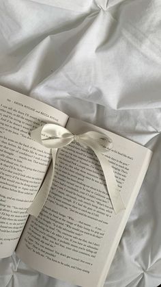 an open book with a bow on it